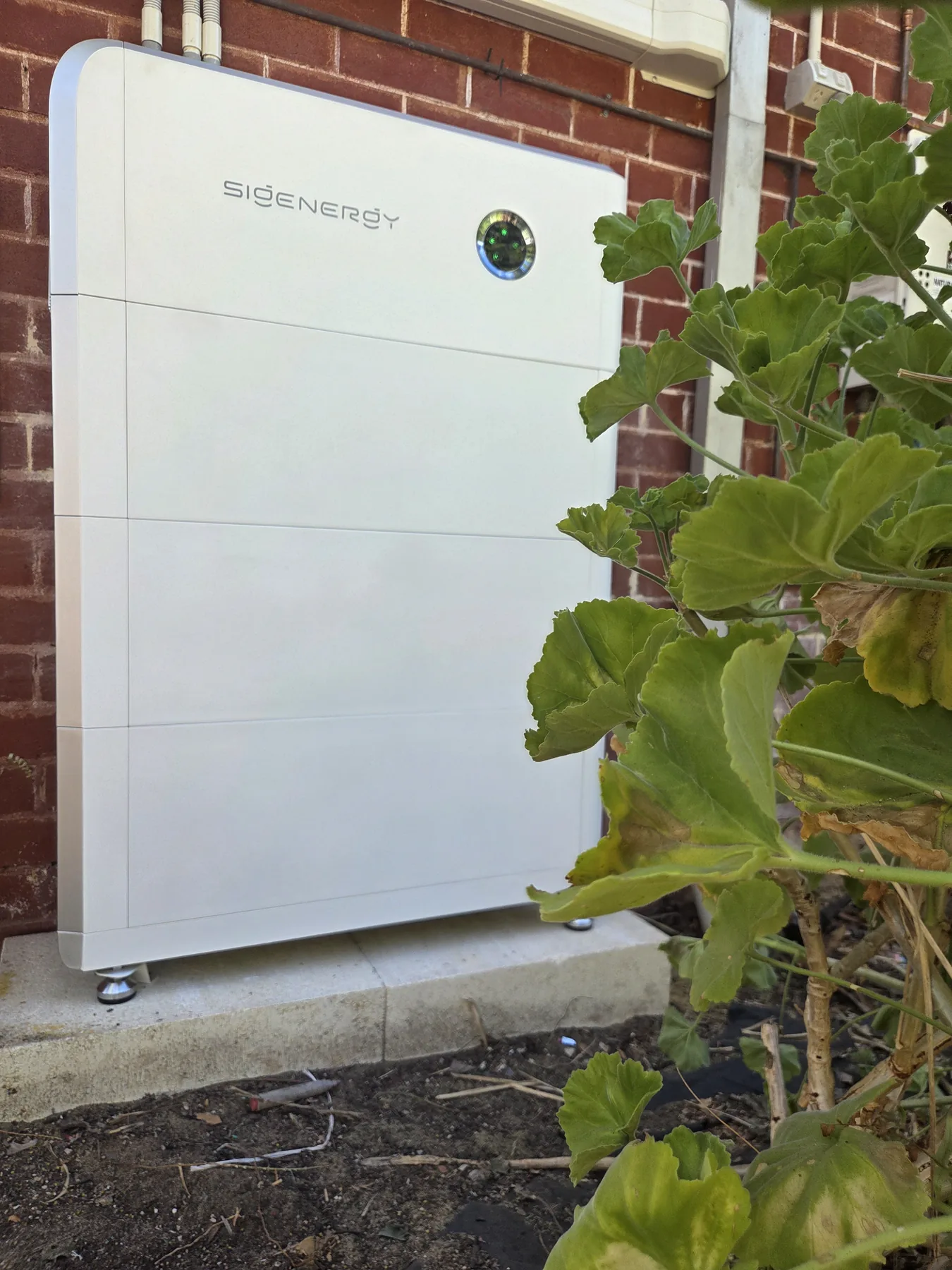 Sigenergy home battery installed by Unisol beside a brick wall